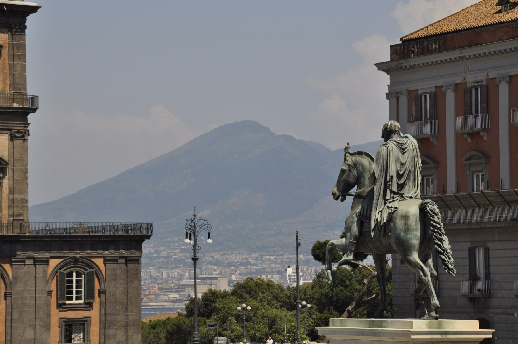 An equestrian statue in Piazza del Plebiscito with Vesuvius behind