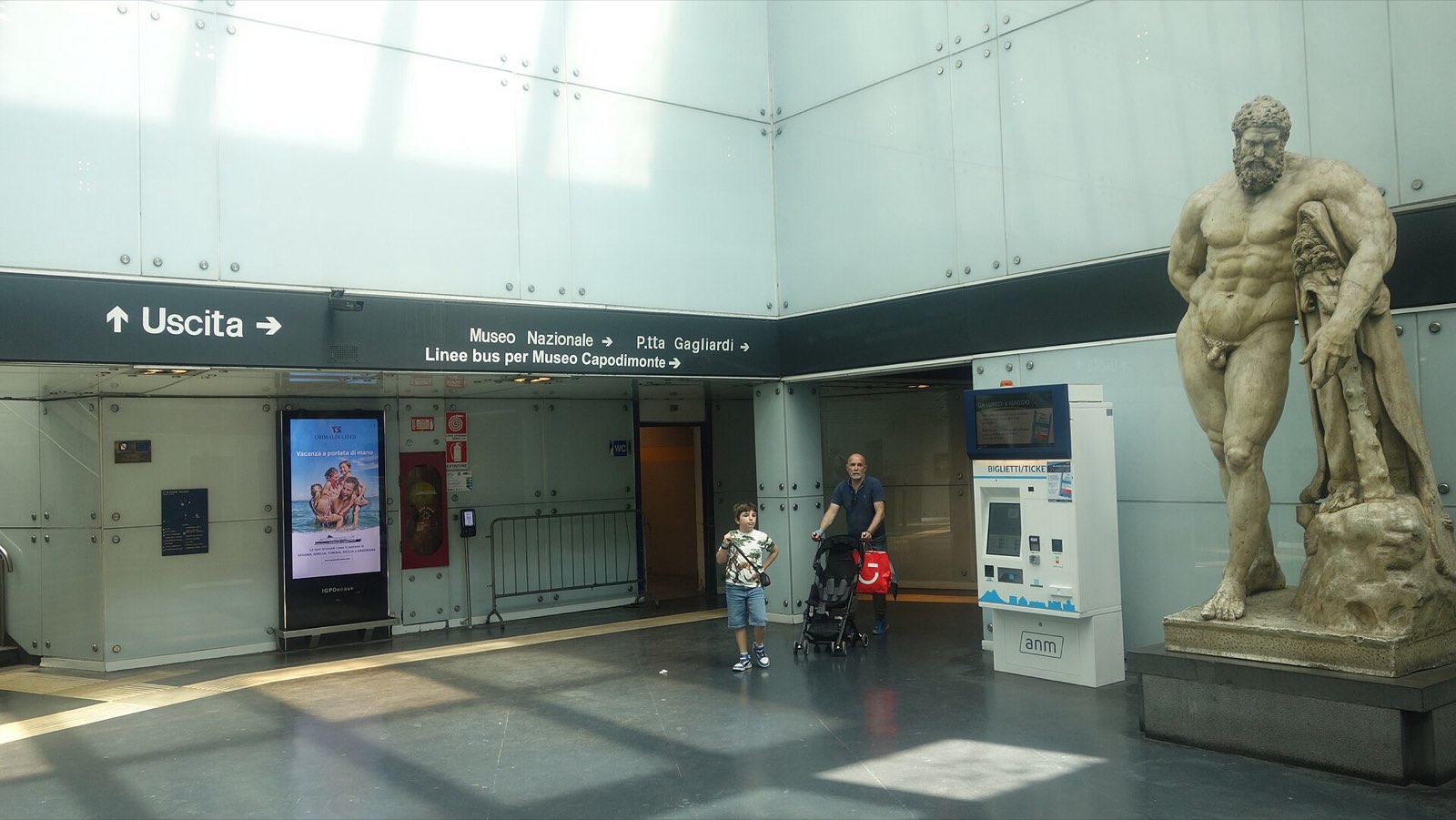 A large statue of Hercules leaning on his club in the hall of Museo station