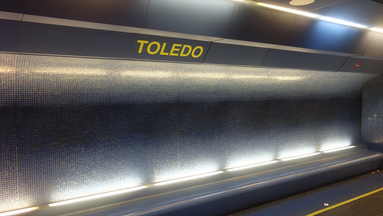 The shimmering blue mosaic wall of Toledo metro station platform